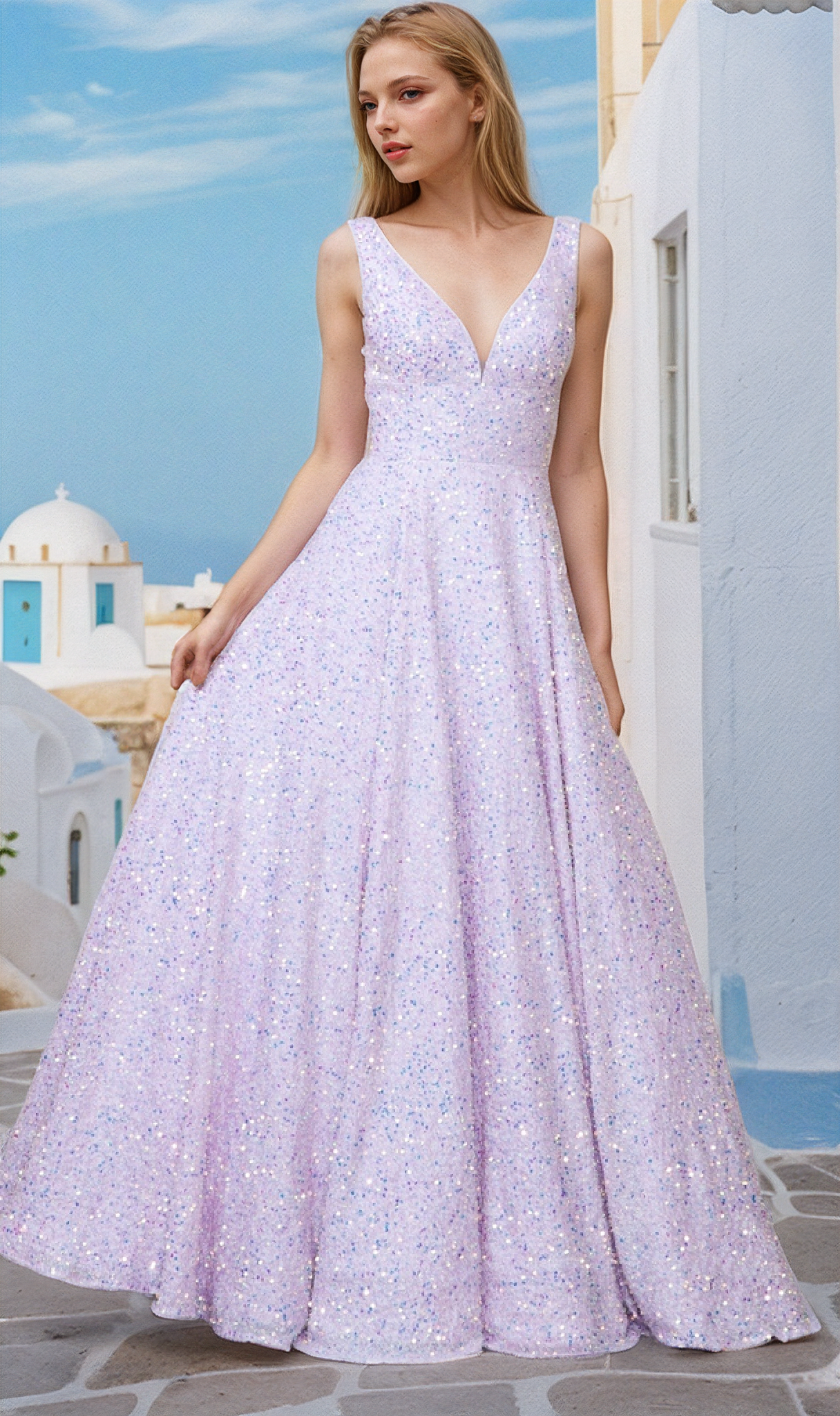 A woman stands outdoors in front of white buildings, wearing the Long Black Sequin A-Line Prom Dress 9168 featuring a sleeveless design, deep V-neck, and a flared skirt.